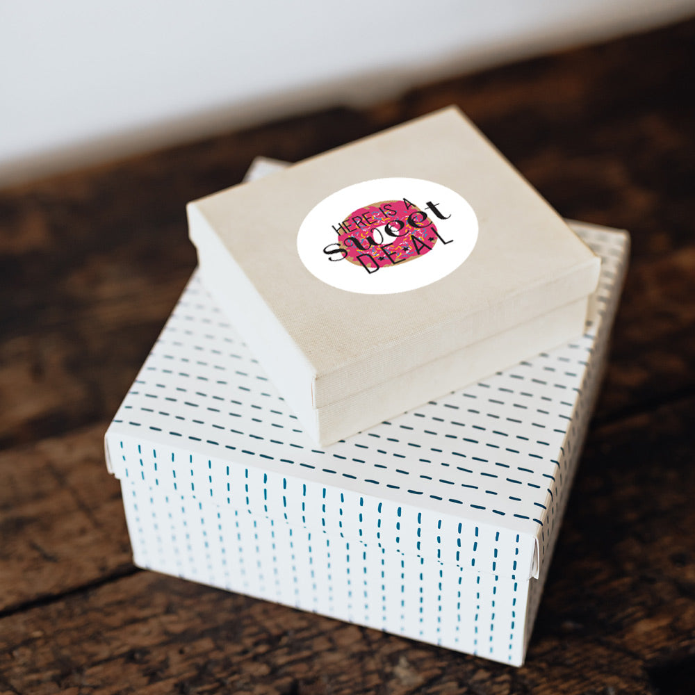 There is a label affixed to a cotton filled box. The label is customized with “Here is a sweet deal”.