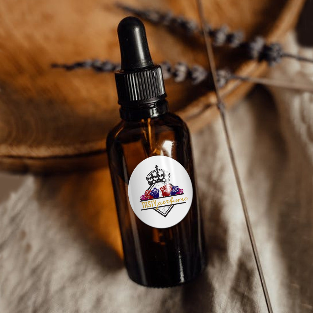 There is a dropper style perfume bottle with a nice custom label affixed to the dropper bottle. The dropper bottle is resting against a wooden bowl.